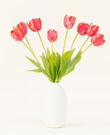 Der künstliche Blumenstrauß „French Tulip Red“ aus Seide ist in einer weißen Keramikvase arrangiert, mit acht roten und gelben Tulpen mit grünen Blättern vor einem schlichten hellen Hintergrund.