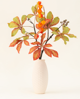 Der Kunstblumenstrauß Autumn Flair aus Seide besteht aus einer Vase mit weißer Struktur und Laternenzweig, orangefarbenen Laternenblüten und grün-roten Blättern, die vor einem schlichten hellen Hintergrund eine stilvolle Herbstdekoration bilden.