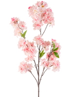 Die künstliche Blume Kirschblüte 119 cm rosa hat mehrere Büschel hellrosa Kirschblütenblüten und grüne Blätter auf einem Zweig vor einem weißen Hintergrund.