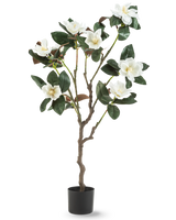 Die künstliche Yulania-Pflanze 120 cm mit Blüte ist ein künstlicher Magnolienbaum in einem Topf mit mehreren Zweigen, großen glänzend grünen Blättern und mehreren weißen Blüten vor einem schlichten weißen Hintergrund.