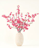Der künstliche Blumenstrauß aus Seide, Kirschblüten-Fuchsia, 150 cm, besteht aus leuchtend fuchsiafarbenen Kirschblütenstielen mit grünen Blättern in einer schlichten weißen Vase, die vor einem hellen Hintergrund jedes Interieur ergänzt.
