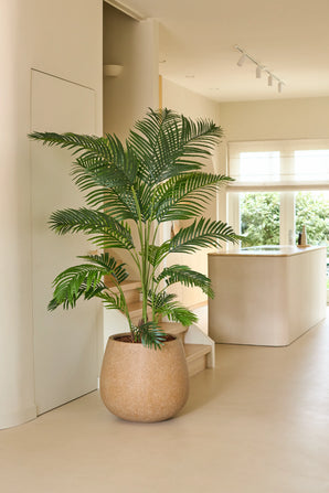 Eine künstliche Chamaedorea-Pflanze von 180 cm steht in einer modernen, hellen Küche mit neutralen Farbtönen, minimalistischem Dekor und natürlichem Licht, das durch die Fenster fällt.