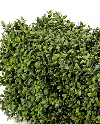 Die künstliche Buchsbaumhecke UV 100x20x25 cm hat eine dichte, quadratische Matte aus künstlichen Buchsbaumblättern in verschiedenen Grüntönen vor weißem Hintergrund.