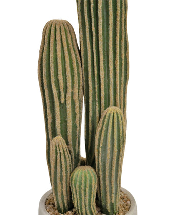 Eine Nahaufnahme des Kunstkaktus 59 cm zeigt mehrere lange, grüne, gerippte Stängel mit gelblichen vertikalen Rillen in einem weißen Topf voller kleiner Kieselsteine.