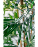 Close-up van lange, slanke groene bladeren met witte strepen van de Lady Kunstpalm 180 cm. De zacht vervaagde achtergrond benadrukt de textuur en kleuren van deze elegante kunstplant.