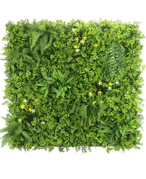 Die künstliche Hecke Narzisse Smile 100x100 cm UV ist eine quadratische vertikale grüne Wand mit dichtem grünem Blattwerk, Farnen und kleinen gelben und weißen Blüten vor einem weißen Hintergrund, von oben gesehen.