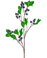 Der künstliche Beerenzweig 76 cm lila hat einen Zweig mit hellgrünen Blättern und Büscheln kleiner, runder, dunkelvioletter Beeren vor einem schlichten weißen Hintergrund.