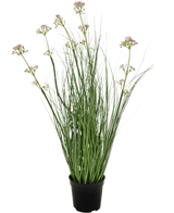 Das feuerhemmende Kunstrasen-Lauchblüten-Zwiebelgras-Bonsai 61 cm hat lange, schlanke grüne Blätter und lange Stiele mit kleinen Büscheln hellvioletter Blüten, präsentiert in einem Topf vor einem schlichten weißen Hintergrund.