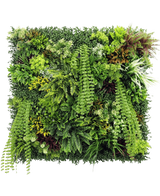 Die künstliche Hecke Lush Deco Deluxe 100 x 100 cm UV ist ein quadratisches vertikales Gartenpaneel mit dichtem, strukturiertem Grün mit einer Mischung aus Laubpflanzen, Farnen und Gräsern – perfekt für die Schaffung einer lebendigen natürlichen Darstellung vor einem weißen Hintergrund.