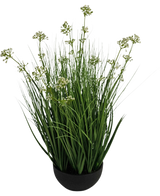Der feuerhemmende Kunstrasen-Lauchblumen-Zwiebelgrastopf (60 cm) hat hohe, dünne, grasähnliche grüne Blätter mit kleinen weißen Blütenbüscheln in einem schwarzen Topf vor einem weißen Hintergrund.