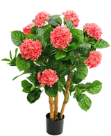 Die künstliche Hortensie UV 85 cm rosa hat mehrere Stiele, breite grüne Blätter und rosa Hortensienblüten in einem schwarzen Topf, was für einen lebendigen Kontrast und ein naturgetreues Aussehen sorgt.